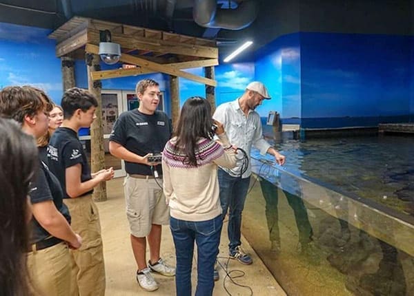 Teen Science Café Network students working with a water tank with instructor